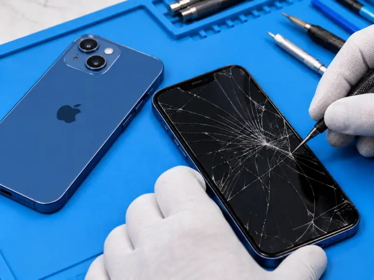 Illustration of a blue iPhone 14 and cracked screen being inspected at a repair workstation